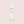 Bottle with white pump filled with light green-yellow cleansing oil, pink background