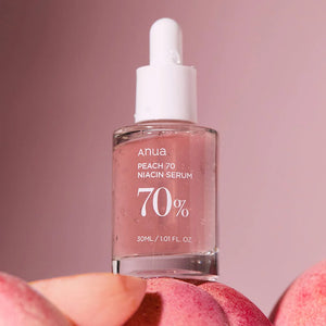 Anua Peach 70% Niacinamide Serum bottle on a background of peach tones, emphasizing the serum's main ingredient.