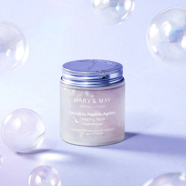 Frosted jar of MARY & MAY Calendula Peptide Ageless Sleeping Mask against a lavender background with floating clear bubbles, highlighting the product's soothing aesthetic.