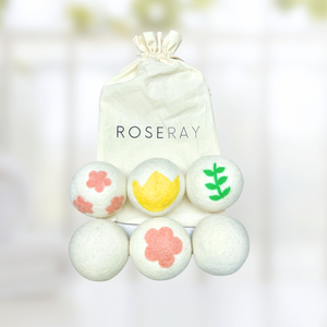 six wool dryer balls with plant and flower designs on them