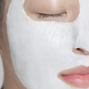 White creamy Anua 70% heatleaf mud mask on women's face