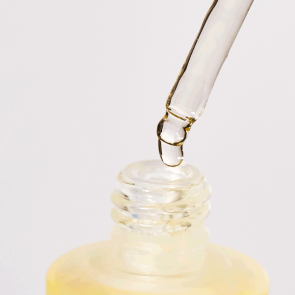 Anua Heartleaf Soothing Ampoule coming out of a dropper and into glass bottle