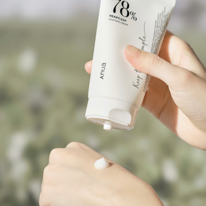 White tube of anua soothing cream opened and squeezed on hand