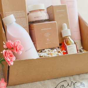 kraft box full of pink Aromatica rose line skincare products.