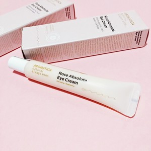 Aromatica Rose Eye Cream in light pink tube with outer box packaging on pink background