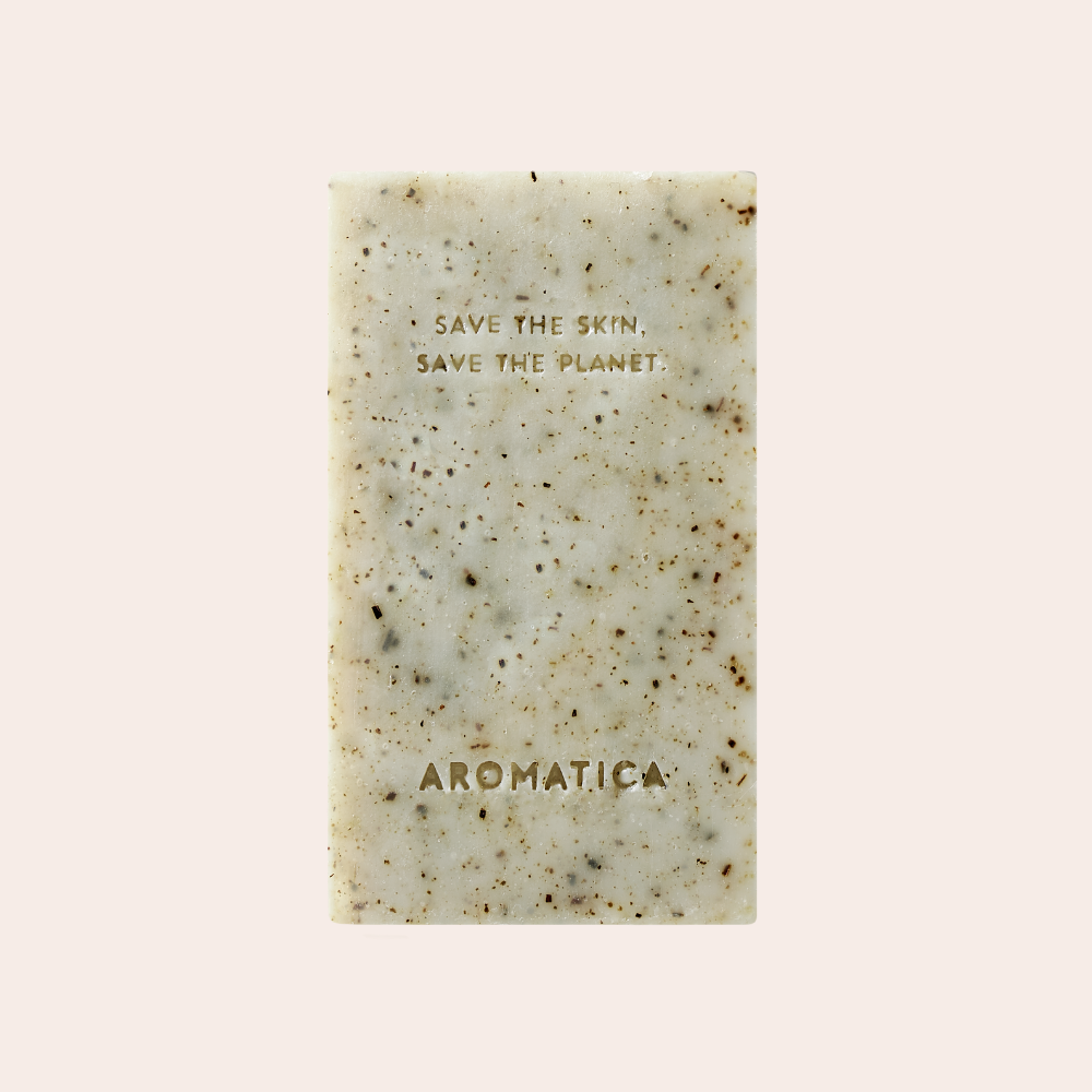 Aromatica Tea Tree Balancing Cleansing Bar shown. Light green with bits of tea tree. Save the skin, save the planet is carved into bar soap.