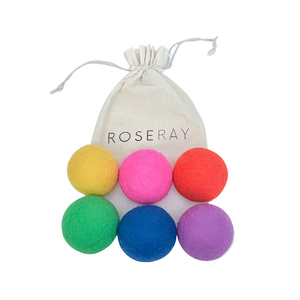 Six Roseray wool dryer balls in colors yellow, pink, orange, green, blue, and purple. Roseray reusable cotton bag also shown.