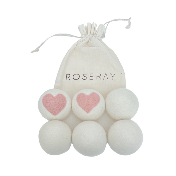 Six Roseray Wool Dryer Balls, two white with baby pink hearts and four white ones. Roseray reusable cotton bag also shown.