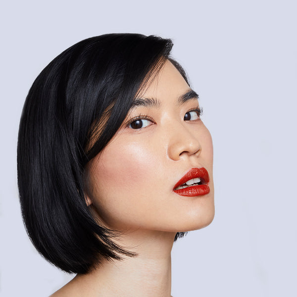 Yulip lipstick in Gochujang, a deep chili red, on model